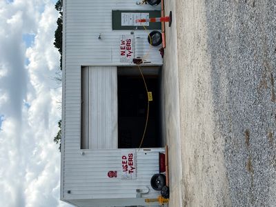 Warehouse with signs for used and new tires on either side of the entrance.