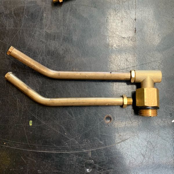 Brass plumbing pipe fitting with two bent tubes.