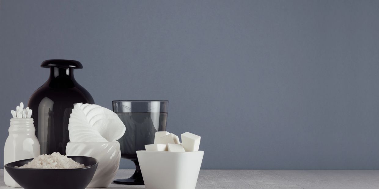 Spa essentials including cotton swabs, bath salts, and towels arranged on a table.