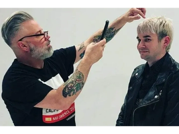 Barber cutting hair of a man with blond dyed hair.