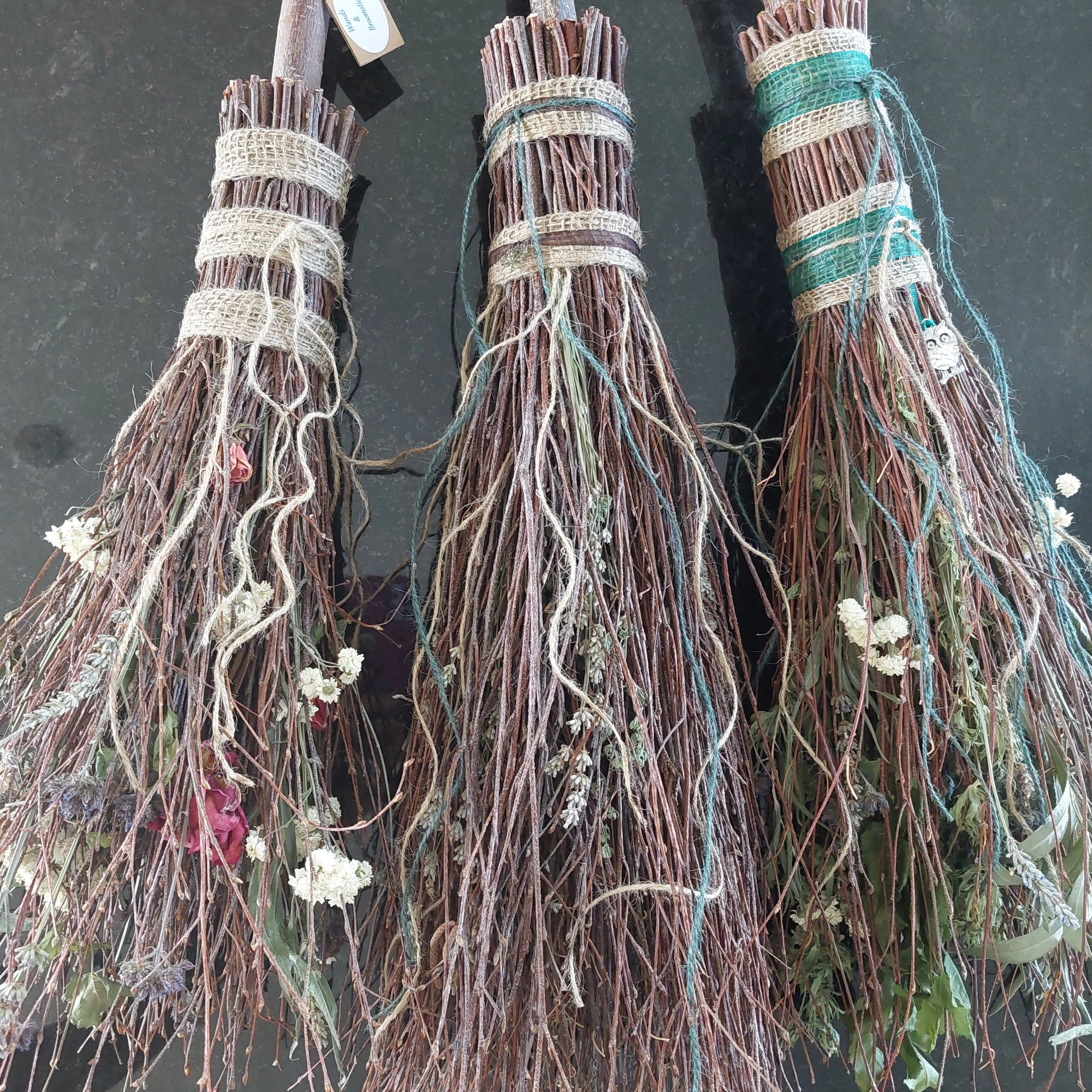 Three bundles of twigs tied with cloth and decorated with dried flowers.