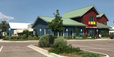 Modern community building with green roofs under blue sky.