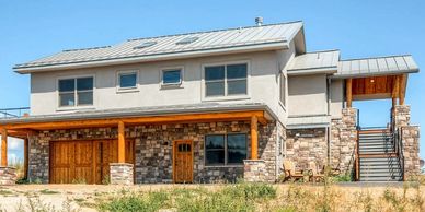 Two-story house with stone and wood elements.