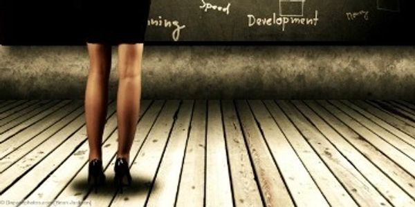 Woman standing in front of a chalkboard with business-related words.