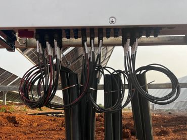 Electrical cables connected to a panel above ground.