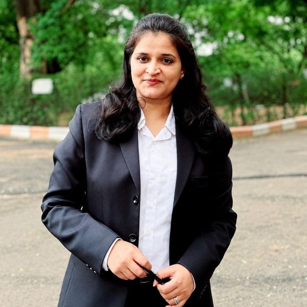 Confident woman in a black blazer outdoors.