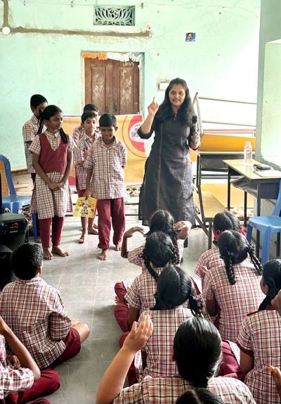Teacher engaging young students in classroom activity.