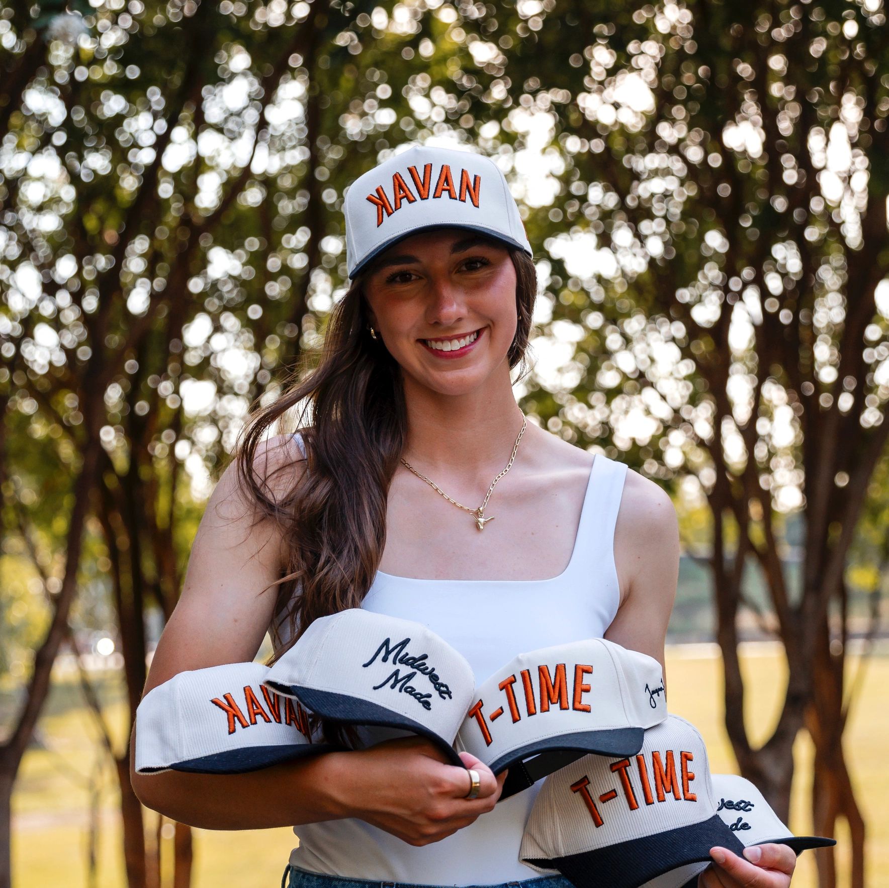 Teagan Kavan holding her custom hat options available for purchase. 