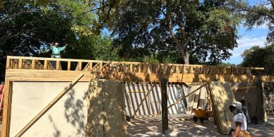 Residential garage renovation with exposed wood framing and temporary supports.