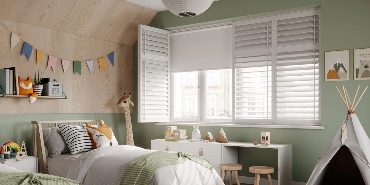 White blackout plantation shutters in a children's bedroom with green walls and natural wood accents.