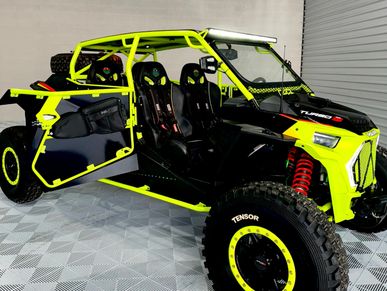 Black and yellow off-road dune buggy with open door.
