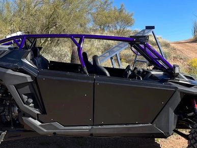 Off-road vehicle with purple frame in desert.
