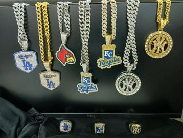 A collection of gold and silver sports-themed chains and rings.