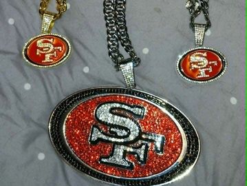 Three San Francisco 49ers glittery logo pendants on chains.
