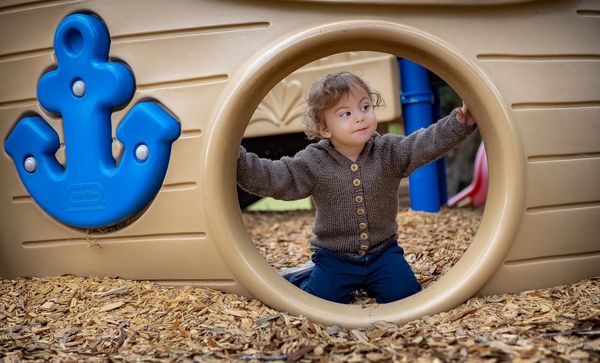 Fine Art Childrens Portrait editorial vibe Charleston SC boy peeking out pirate ship on playground