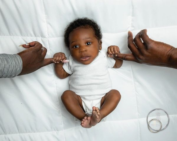 Fine Art Newborn Portrait editorial vibe Charleston SC baby on white holing index finger of parents