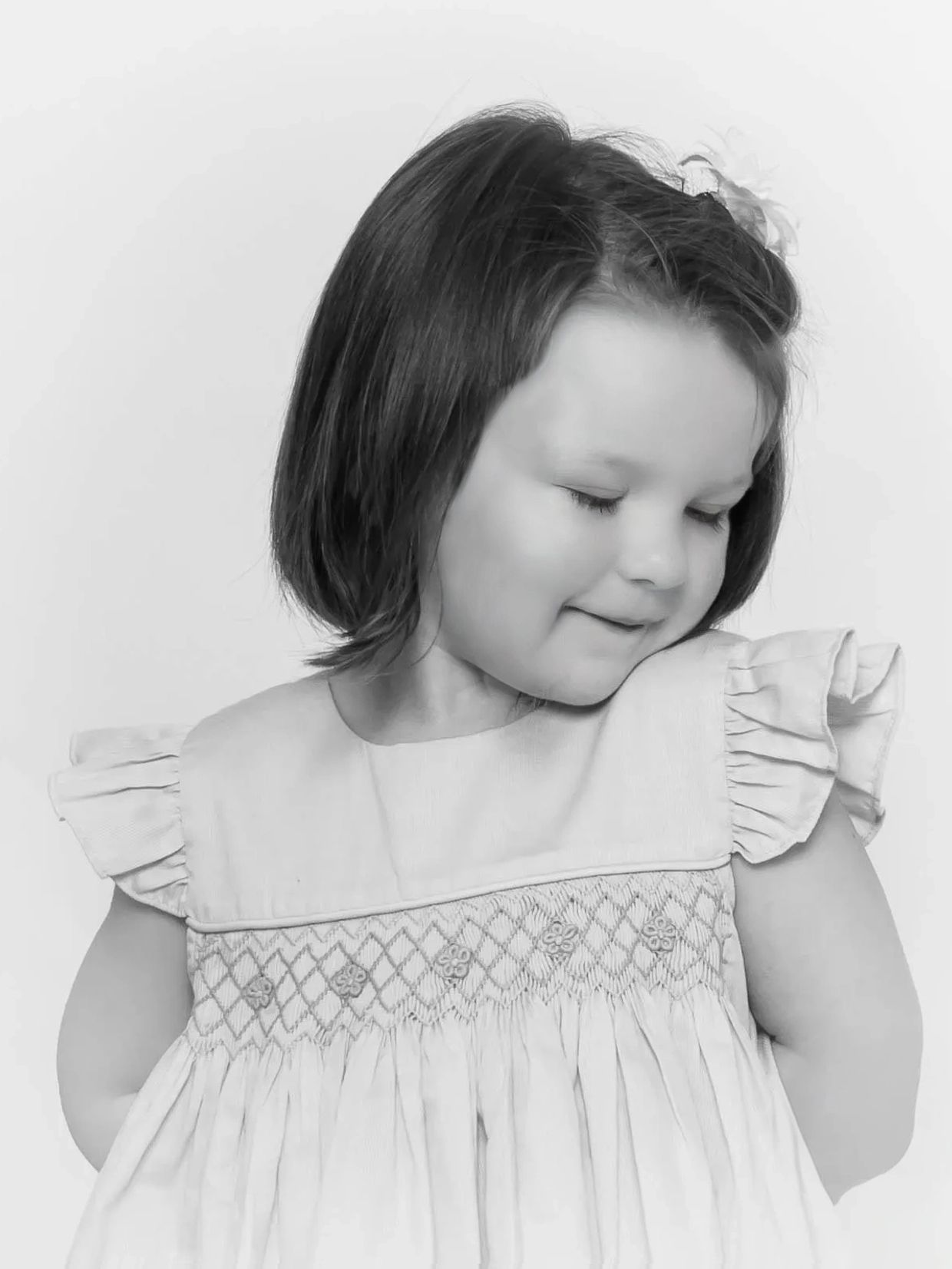 Timeless personality portrait of a toddler girl being shy, done in black and white 