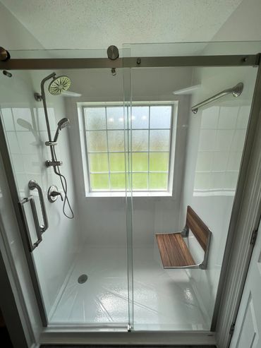Jacuzzi walk-in shower in white with a window