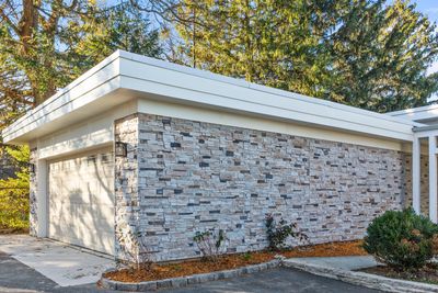 garage with faux stone on walls and exterior lights