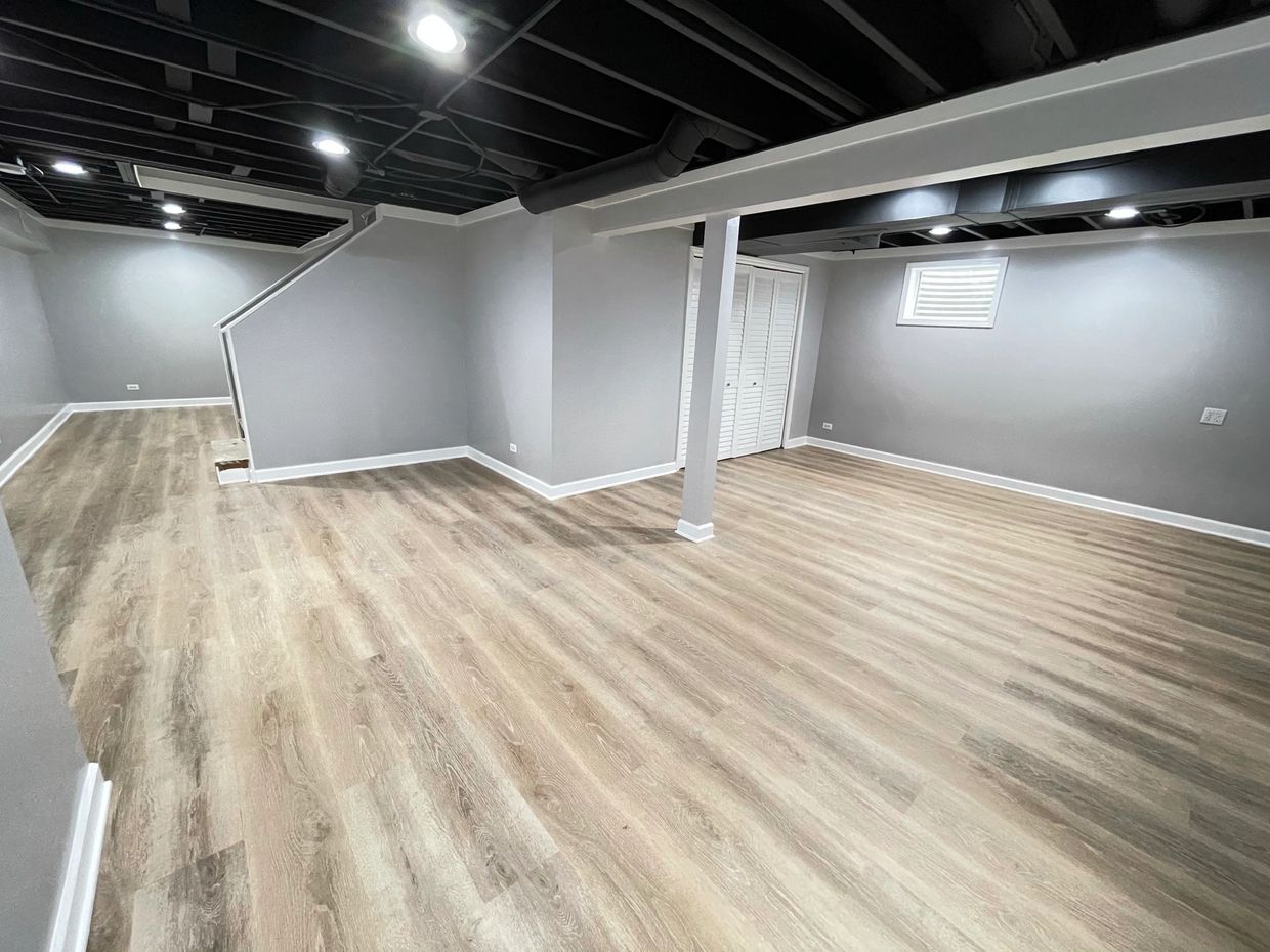 finished basement with vinyl plank flooring and gray walls