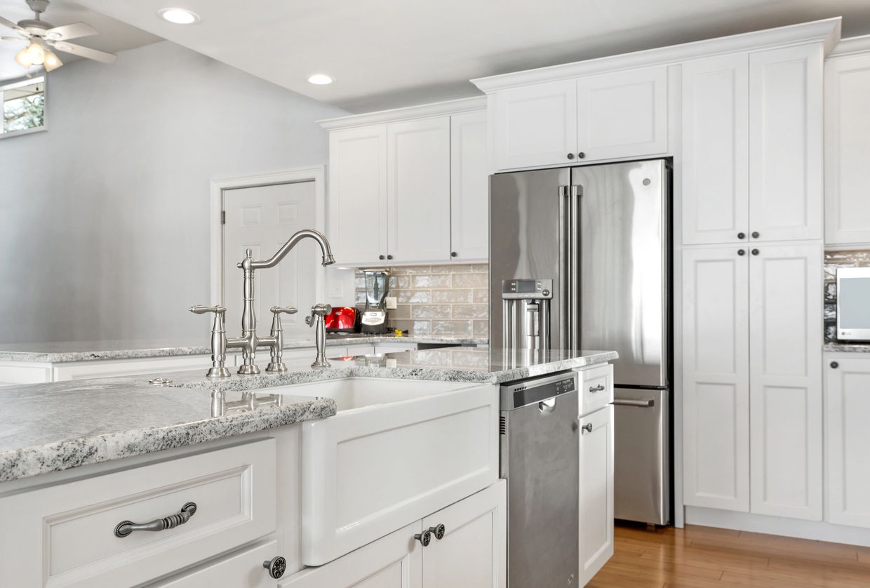 white kitchen with stainless steel refrigerator and kitchen sink faucet