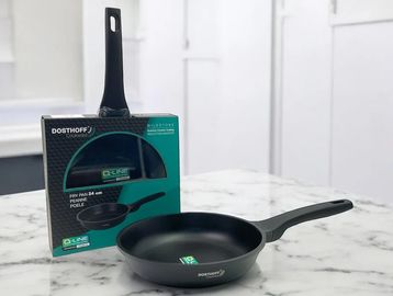A black Dosthoff frying pan and its packaging on a marble countertop.