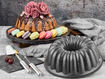 Bundt cakes and colorful macarons on a table.