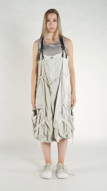 Woman wearing baggy, light-colored overalls with a loose fit and casual sneakers.