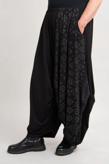 Pantalon ample noir avec motif géométrique.