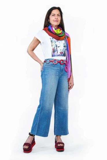 Woman in colorful scarf, graphic tee, wide-leg jeans, and platform sandals.
