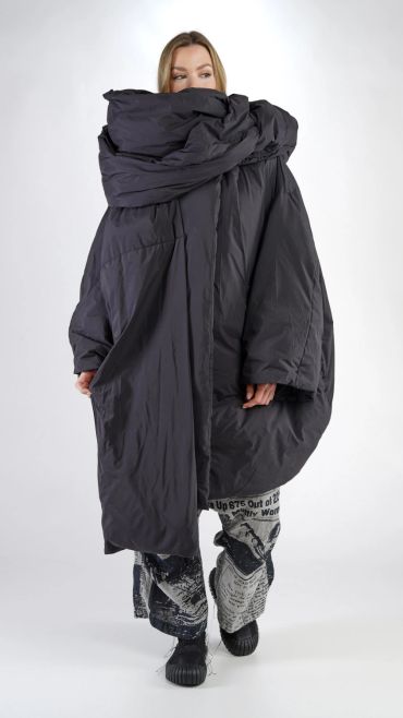 Femme portant un manteau noir oversize et pantalon imprimé.