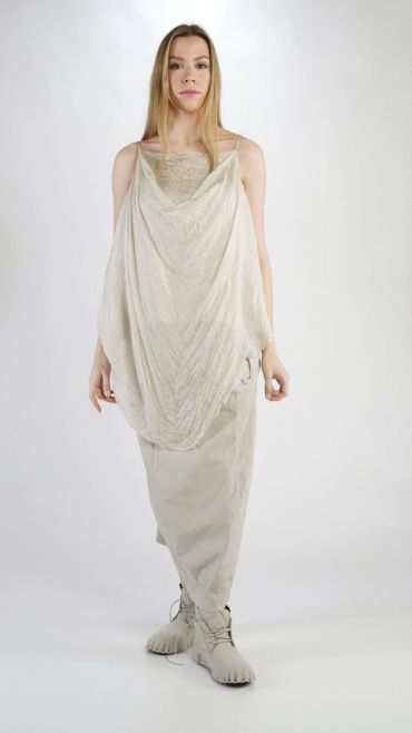 Femme portant une robe beige fluide avec des chaussures assorties.