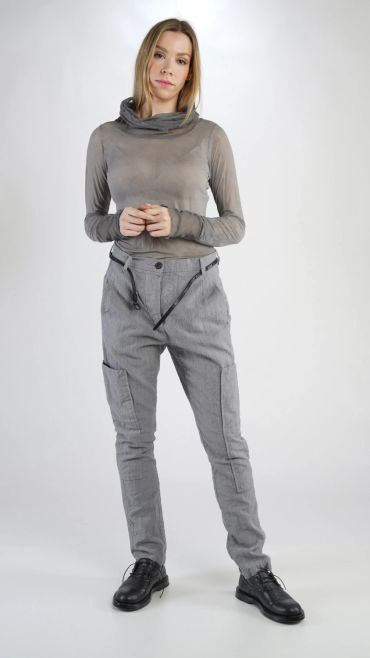 Femme debout en tenue grise moderne.