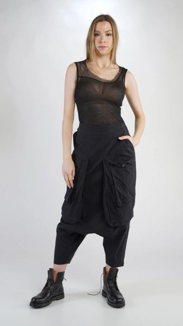 Femme portant un haut noir transparent et un pantalon large noir.