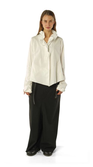 Woman in a white blouse and black wide-leg pants.