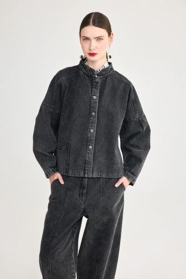 Woman in black denim jacket and pants.