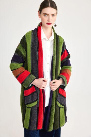 Woman wearing a colorful striped coat over a white shirt.