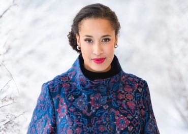 Woman in a blue patterned coat outdoors.