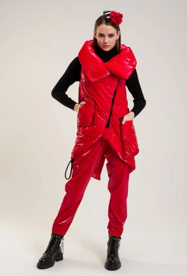 Woman in bold red puffer vest and pants with black boots.
