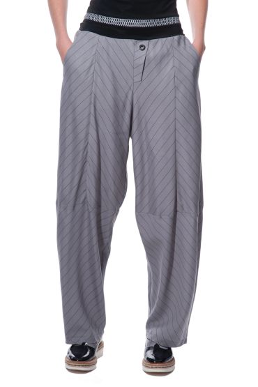 Woman wearing loose grey striped pants and black shoes.