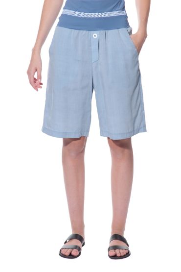 Woman wearing light blue long shorts and black sandals.