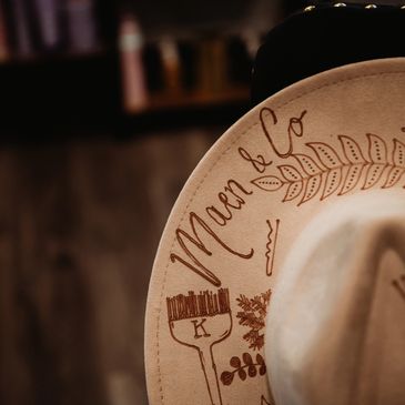 Close-up of a beige hat with intricate designs and text.
