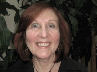 Smiling woman with shoulder-length reddish hair.