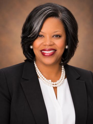 Professional woman with pearl necklace and black blazer.