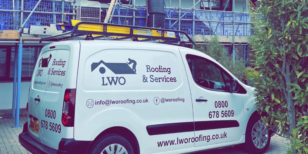 Van with roofing services advertisement.