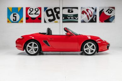 Red convertible sports car in a white showroom.