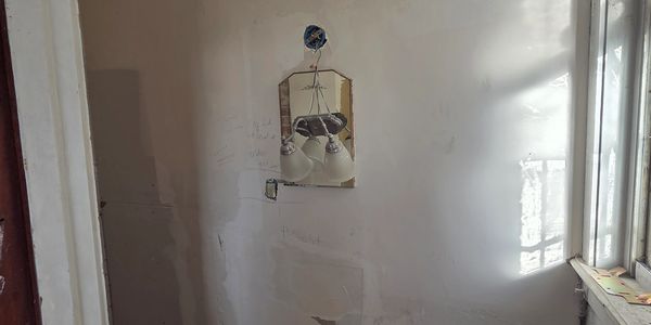 Indoor wall with a mounted light fixture and window light.