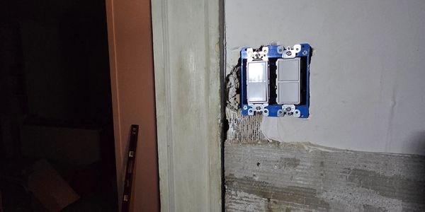 Unfinished wall with two light switches installed.