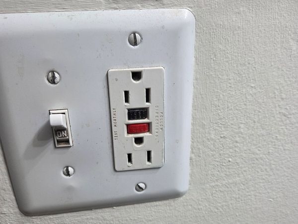 Wall switch and GFCI outlet in the off position.