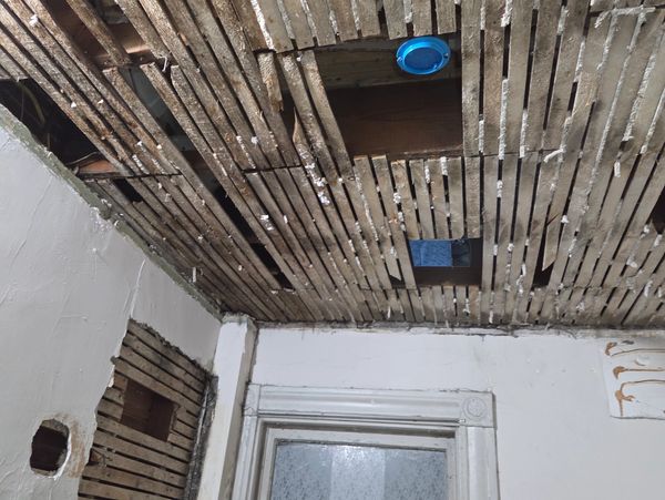 Exposed wooden lath ceiling in a room under renovation.
